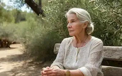 Una anciana sentada en un banco de olivo