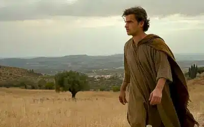 Un joven con ropas desgastadas camina al borde de un paisaje mediterráneo lúgubre