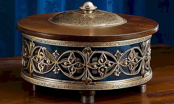 Un viejo cernedor de piedra está expuesto en una mesa de madera pátinaada, rodeado de belleza y elegancia antigua