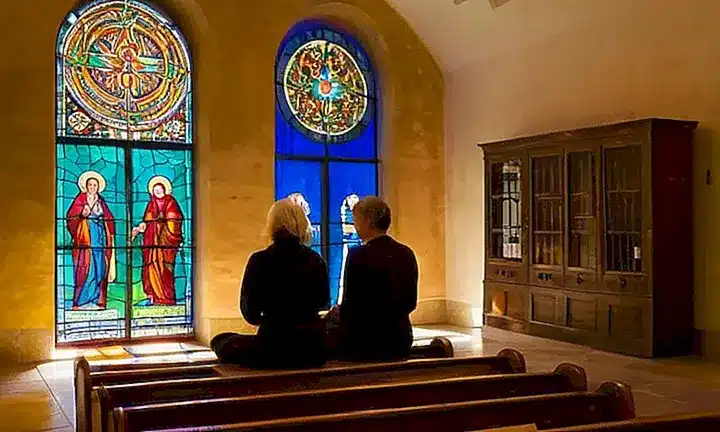 Un grupo de personas devotas se reúne en una iglesia tranquila para un ritual de adoración humilde y repleta de belleza