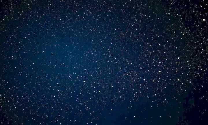 Este fondo de pantalla tiene un diseño impresionante que simula las galaxias con estrellas y nubes, en tonos brillantes de amarillo, naranja y rosa sobre un fondo azul profundo