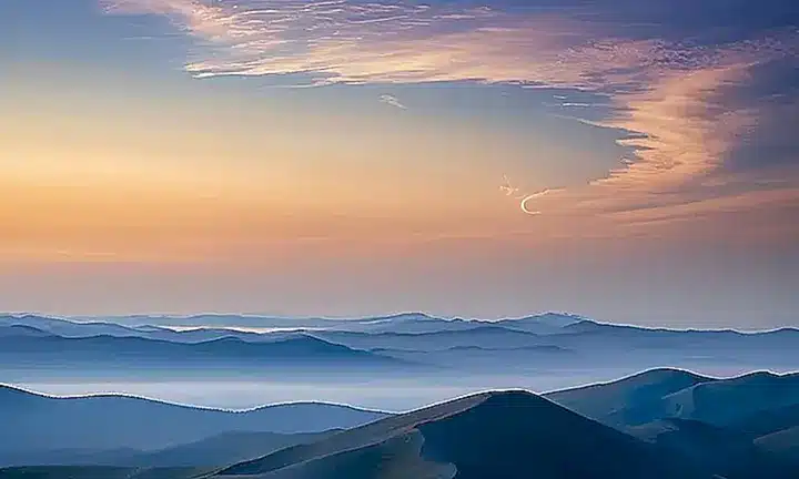 La pintura muestra un cielo con una suave grada de colores y nubes de diferentes tamaños que crean efectos de luz y sombra