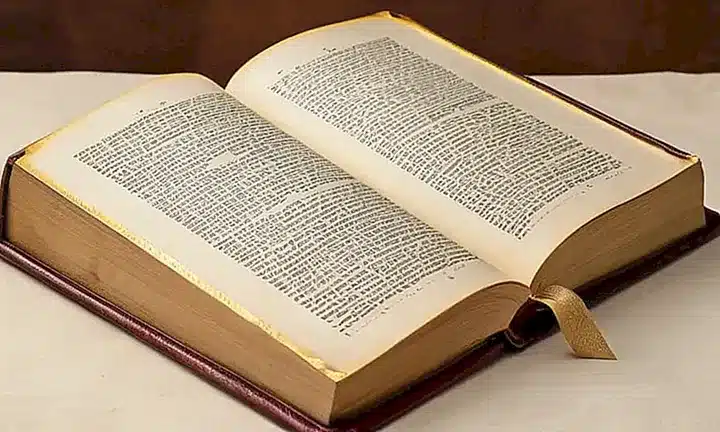 Una Biblia antigua con cubierta de cuero desgastada y páginas amarilladas que parece haber sido leída y manipulada a lo largo del tiempo
