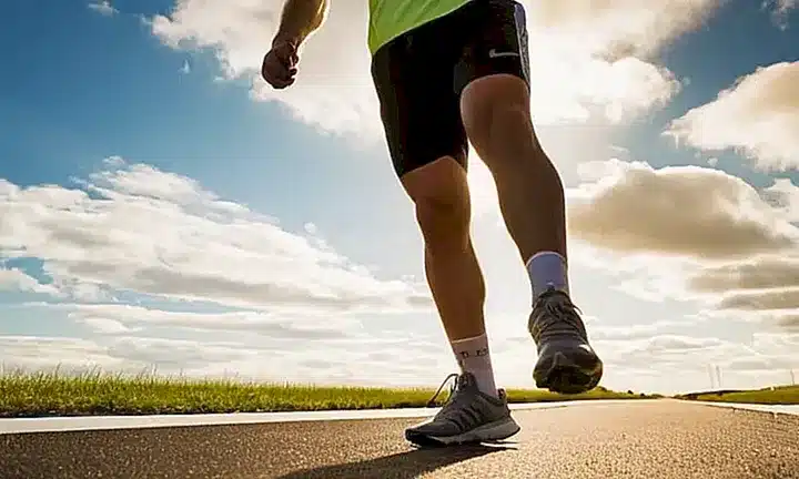 Un joven atlético se mantiene en posición de carrera con los ojos enfocados hacia adelante