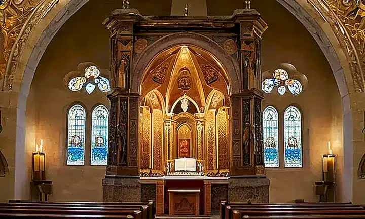 La habitación es una iglesia católica tradicional con detalles arquitectónicos ornamentados y luces naturales que crean un ambiente sereno y reverente