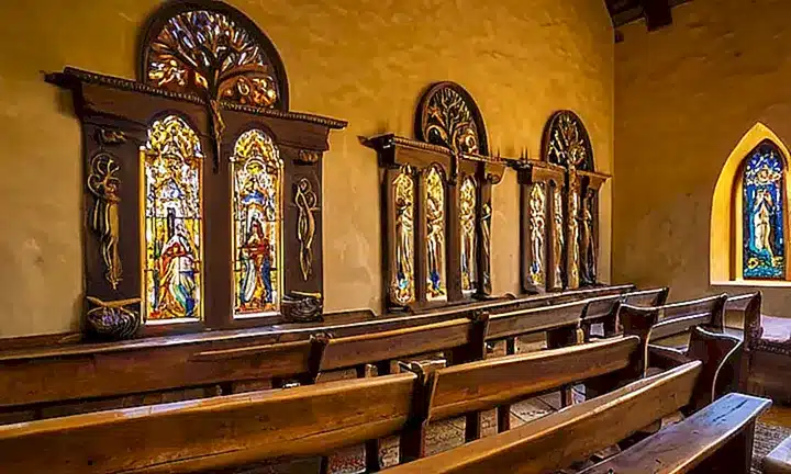 La luz del sol y las velas iluminan la capilla antigua con escenas de vida cotidiana junto a las narrativas bíblicas, reflejadas en su piso, muros y detalles decorativos