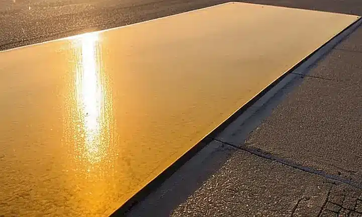 La carretera está flanqueada por un letrero de dirección amarillo con caracteres elevados y sombreado en negro que se alinean perfectamente con el horizonte