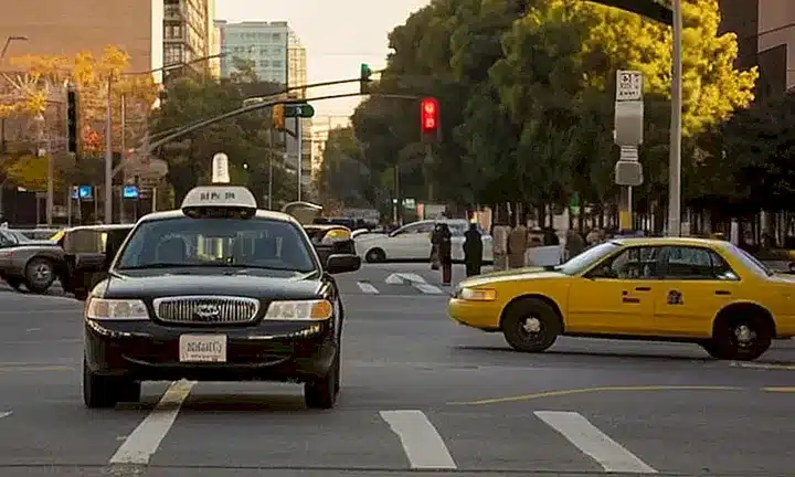 La calle se encuentra llena de personas dirigiéndose al trabajo, autos y edificios en el centro urbano de la ciudad