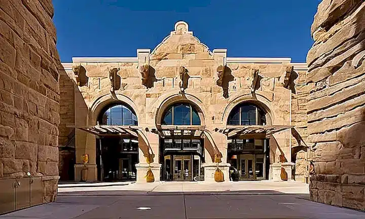 La grandiosa entrada del Museo de Historia Natural de Utah cuenta con un arco majestuoso rodeado por edificios de piedra color arena utahense