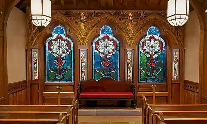 El interior del templo está iluminado por una luz suave que destaca sus elementos ornamentales de madera tallada y piedra blanca
