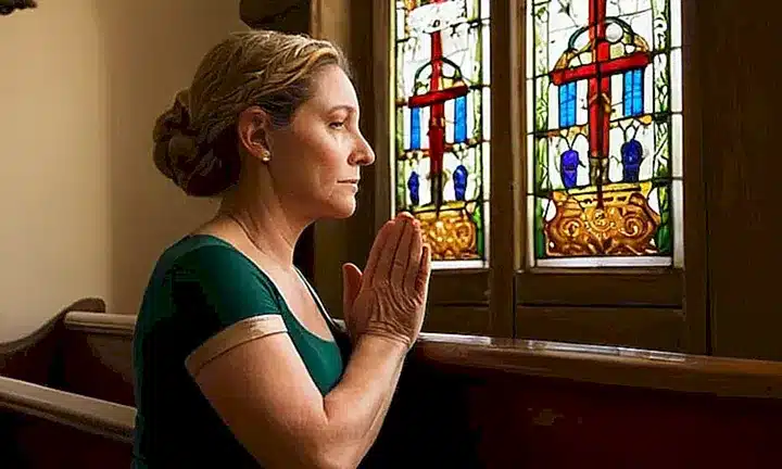 Una mujer religiosa sentada en una iglesia
