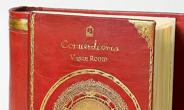 El libro antiguo tiene cubierta de cuero desgastado, páginas amarillentas y una estructura sujeta firmemente con costuras invisibles