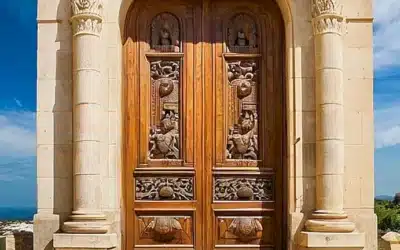 La imagen describe una gran puerta de madera ornada con intrincadas tallas en piedra sobre un fondo célebre con nubes